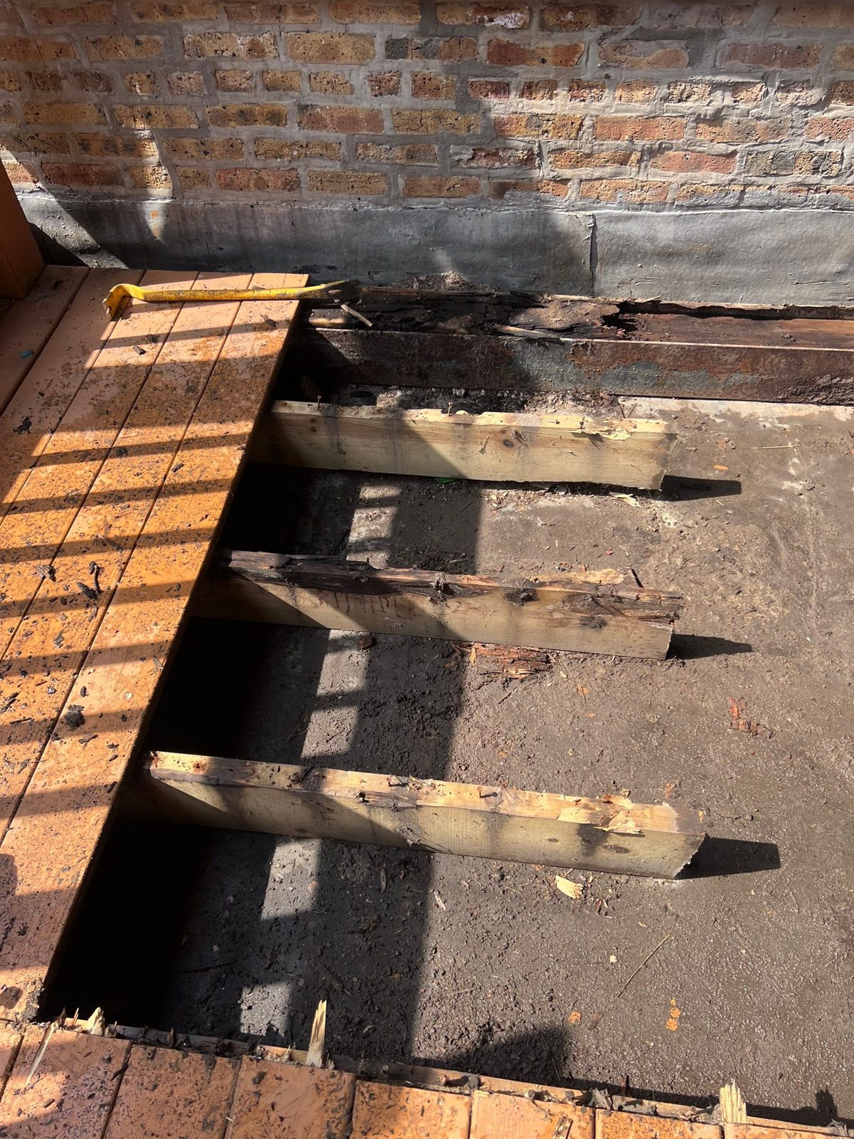 Concrete deck slab exposed during exterior repair at brick wall.