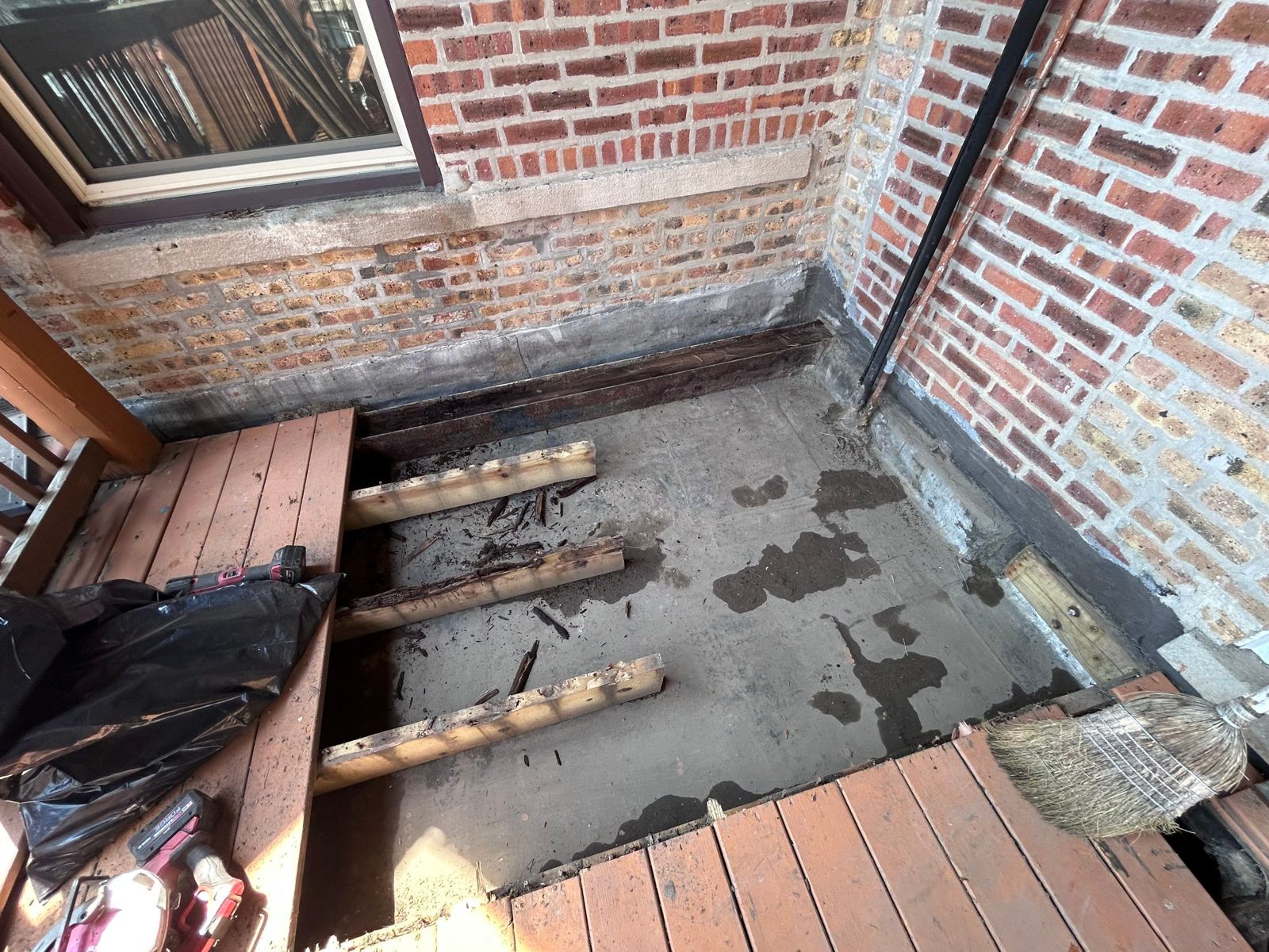 Concrete slab and deck framing at brick-wall interface.