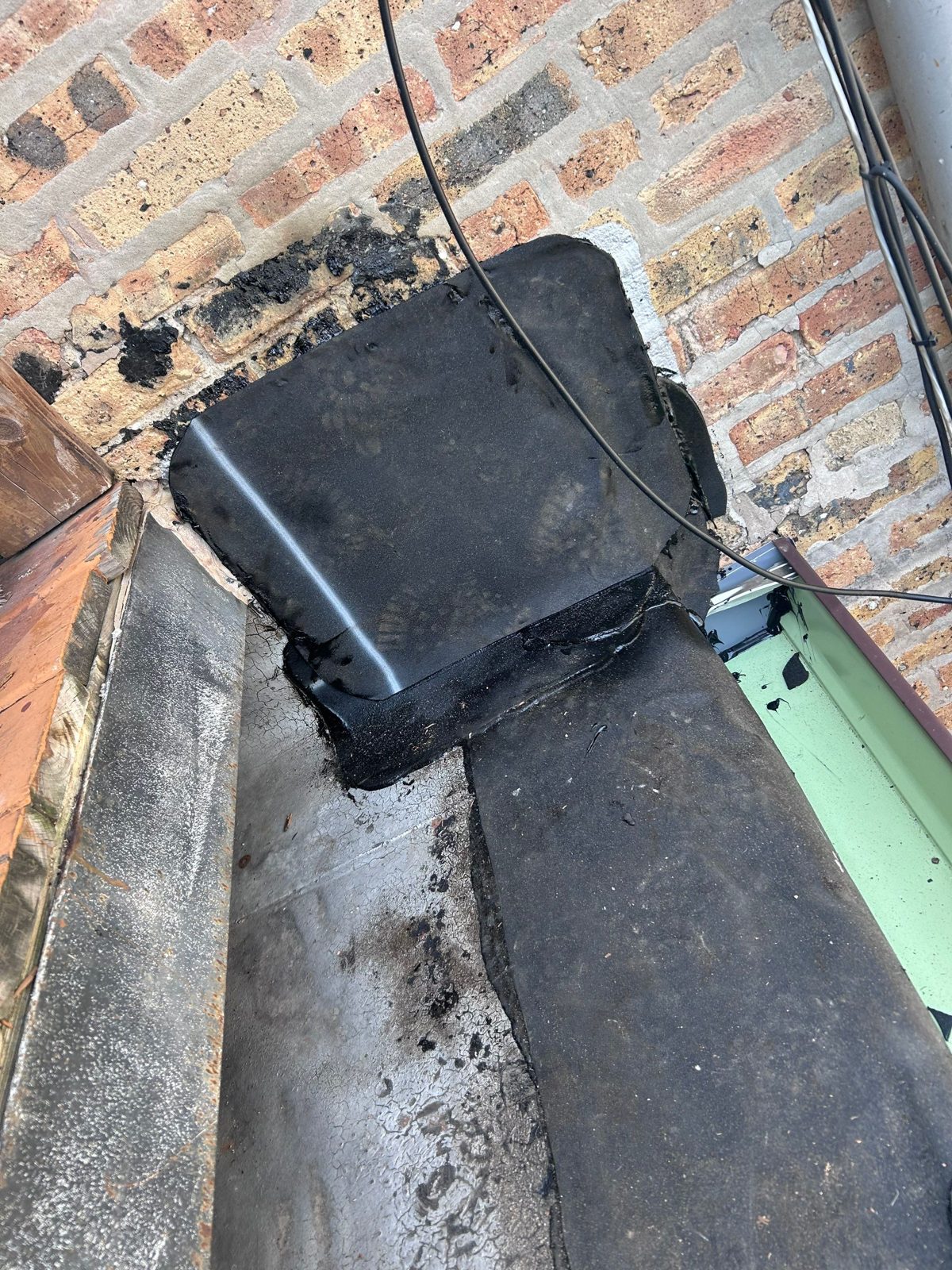 Chimney and brick waterproofing seal detail in progress.