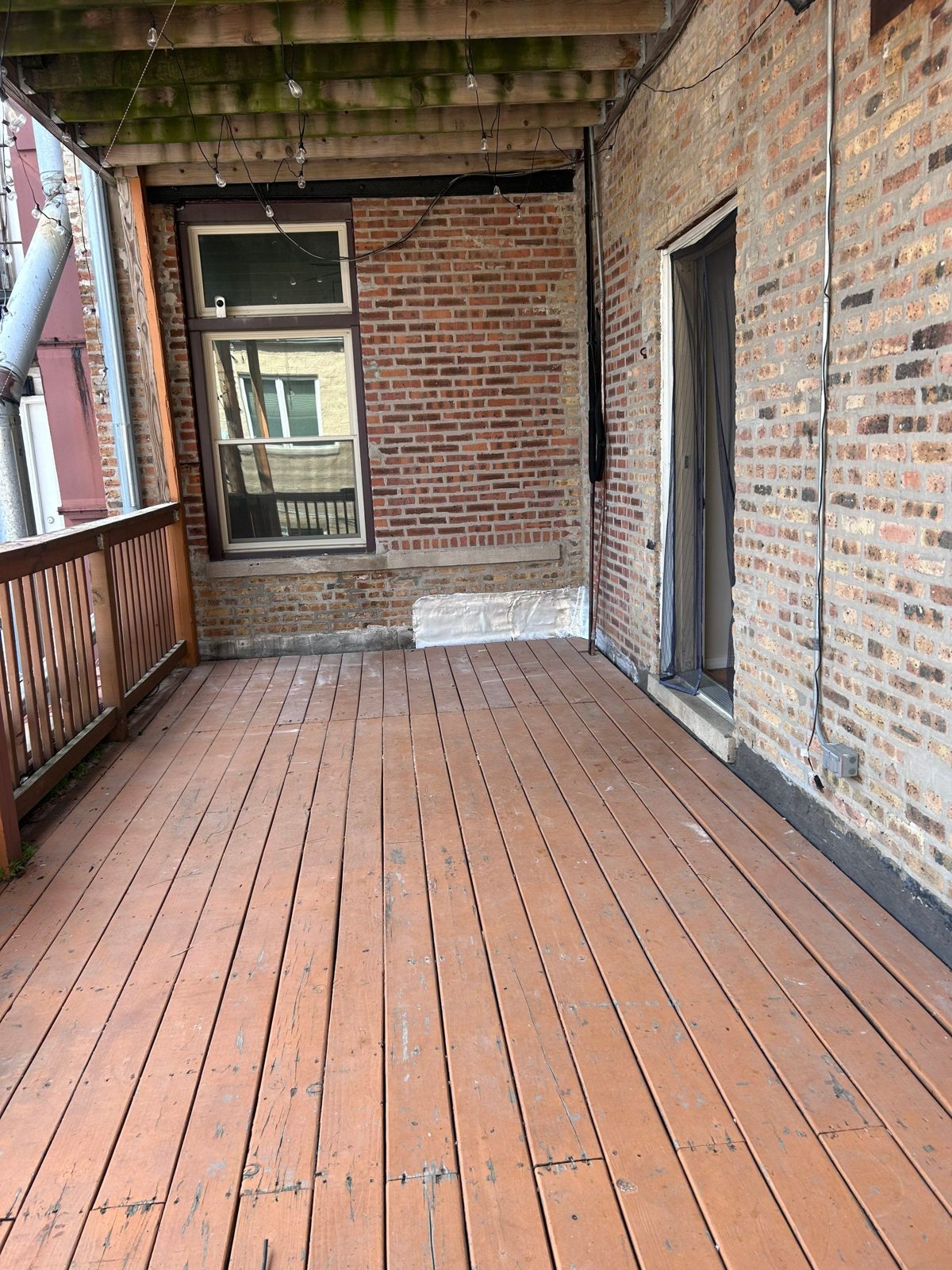 Brick courtyard walls beside finished deck boards.