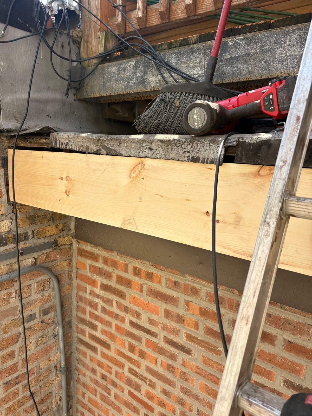 Brick wall and beam repair in progress.