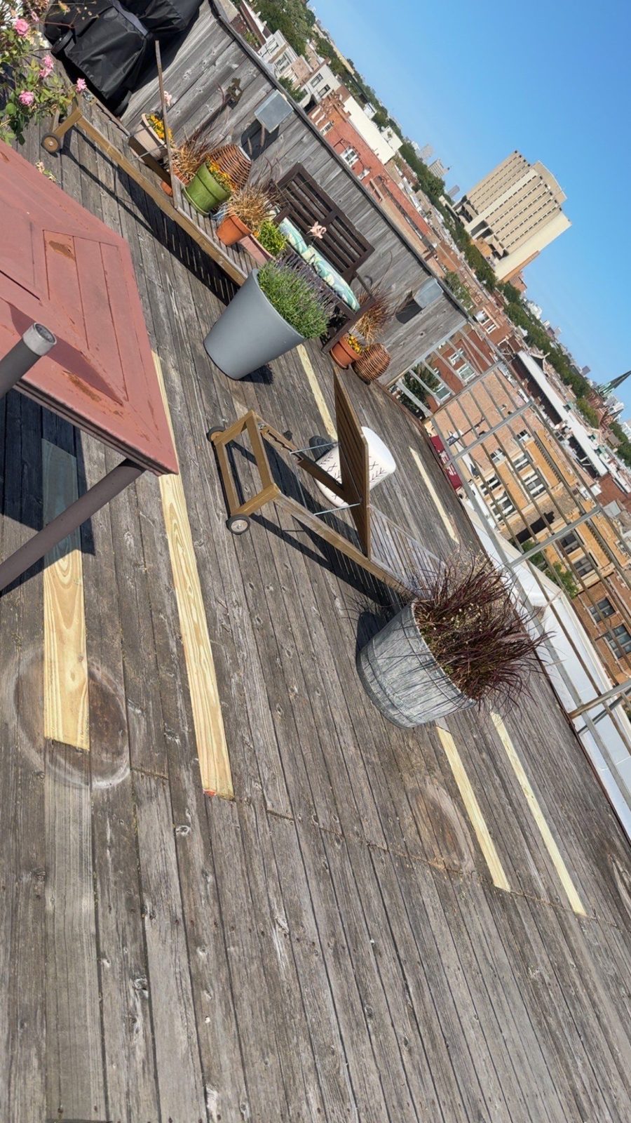 Rooftop deck with fresh board repairs and downtown Chicago skyline.